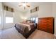 Well-lit bedroom with a ceiling fan, comfortable bedding, and a dresser for storage at 14725 S 182Nd Dr, Goodyear, AZ 85338