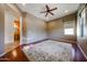 Bright and spacious bedroom featuring hardwood floors, ceiling fan, ample natural light, and an ensuite bathroom at 14725 S 182Nd Dr, Goodyear, AZ 85338