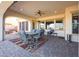 Spacious outdoor patio with brick flooring, fan, dining table, comfortable seating, and views beyond at 14725 S 182Nd Dr, Goodyear, AZ 85338