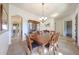 Bright dining room featuring hardwood table with seating for six under a modern chandelier fixture at 14725 S 182Nd Dr, Goodyear, AZ 85338