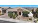 Front exterior of home with manicured landscaping, brick accents, a tile roof, and mountain views at 14725 S 182Nd Dr, Goodyear, AZ 85338