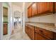 Hallway with travertine flooring, wooden cabinets with granite countertop, and view of dining area at 14725 S 182Nd Dr, Goodyear, AZ 85338