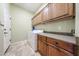 Bright laundry room with travertine flooring, cabinets and white washer and dryer at 14725 S 182Nd Dr, Goodyear, AZ 85338