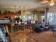 Open concept living room with travertine floors, pendant lights, kitchen island and comfortable seating at 14725 S 182Nd Dr, Goodyear, AZ 85338