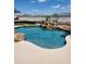 Backyard swimming pool with rock features, deck and desert landscaping for a luxurious outdoor experience at 14725 S 182Nd Dr, Goodyear, AZ 85338