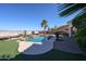 Backyard pool featuring mature palms, lush landscaping, a rock waterfall feature, and desert mountain views at 14725 S 182Nd Dr, Goodyear, AZ 85338