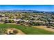 This aerial showcases the community homes bordering the lush green golf course with mountain views at 15240 N Clubgate Dr # 168, Scottsdale, AZ 85254