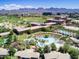 Aerial view of community pool, manicured landscape, and the surrounding neighborhood with mountain views at 15240 N Clubgate Dr # 168, Scottsdale, AZ 85254