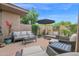Serene back patio featuring comfortable seating, lush plants, and a shaded umbrella for relaxation at 15240 N Clubgate Dr # 168, Scottsdale, AZ 85254