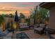 Inviting back patio at dusk with cozy seating, desert landscaping, and a relaxing ambiance at 15240 N Clubgate Dr # 168, Scottsdale, AZ 85254