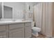 Neat bathroom with single sink vanity, white toilet, and shower with curtain at 15240 N Clubgate Dr # 168, Scottsdale, AZ 85254
