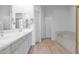 Bright bathroom featuring double sinks, a soaking tub, and neutral-toned tile flooring at 15240 N Clubgate Dr # 168, Scottsdale, AZ 85254