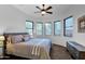 Inviting bedroom featuring plush bedding, a ceiling fan, and multiple windows for natural light at 15240 N Clubgate Dr # 168, Scottsdale, AZ 85254