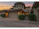 Charming home at twilight with a tan exterior, two-car garage, and manicured landscaping at 15240 N Clubgate Dr # 168, Scottsdale, AZ 85254