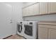 Well-equipped laundry room featuring upper cabinets and modern washer and dryer at 15240 N Clubgate Dr # 168, Scottsdale, AZ 85254