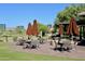 Charming outdoor patio seating area with umbrellas and well-maintained landscaping and mature trees at 15240 N Clubgate Dr # 168, Scottsdale, AZ 85254