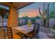 Warm evening view of the covered patio dining area framed by desert landscaping at 15240 N Clubgate Dr # 168, Scottsdale, AZ 85254