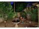 Charming backyard showcasing a tiered fountain, lush greenery, and ambient lighting for a relaxing outdoor space at 15550 N Frank Lloyd Wright N Blvd # 1040, Scottsdale, AZ 85260