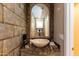 Unique powder room featuring a stone vessel sink, decorative mirror, and textured wall at 15550 N Frank Lloyd Wright N Blvd # 1040, Scottsdale, AZ 85260