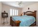 Charming bedroom with a decorative wooden headboard, ceiling fan, and picture window at 15550 N Frank Lloyd Wright N Blvd # 1040, Scottsdale, AZ 85260