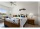 Cozy bedroom with a wooden bed frame, couch seating, and a bright window letting in natural light at 16974 W Marcos De Niza Dr, Surprise, AZ 85387