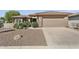 Inviting home with a spacious driveway, well-manicured desert landscaping, and a two-car attached garage at 16974 W Marcos De Niza Dr, Surprise, AZ 85387