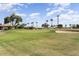 Scenic view of the lush green golf course with blue skies and palm trees in the background at 16974 W Marcos De Niza Dr, Surprise, AZ 85387