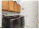 Modern laundry room with front load washer and dryer and overhead cabinets for storage at 16974 W Marcos De Niza Dr, Surprise, AZ 85387
