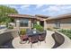 Charming patio with black metal table, chairs, and lovely landscaping, perfect for outdoor dining and relaxation at 16974 W Marcos De Niza Dr, Surprise, AZ 85387