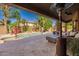 Relaxing backyard with a covered patio, travertine tile, a built-in fire pit, and a view of the pool and waterfall at 1808 S Sailors Way, Gilbert, AZ 85295