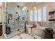 Bright and airy bathroom with standalone tub and walk-in glass shower with herringbone tile at 1808 S Sailors Way, Gilbert, AZ 85295
