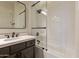 Bathroom featuring a shower with glass surround, dark-stained vanity with quartz countertop, and white subway tile at 1808 S Sailors Way, Gilbert, AZ 85295