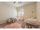 Cozy bedroom with two twin beds, plush rug, and neutral decor under a ceiling fan at 1808 S Sailors Way, Gilbert, AZ 85295