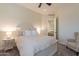Well-lit bedroom with light-colored walls and bedding plus a carpeted floor and a chair at 1808 S Sailors Way, Gilbert, AZ 85295