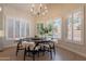 Dining area with round table, four chairs, chandelier, and large window shutters at 1808 S Sailors Way, Gilbert, AZ 85295