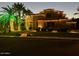 Well-lit home exterior with a manicured lawn and palm trees create inviting curb appeal at 1808 S Sailors Way, Gilbert, AZ 85295