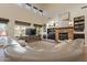 Spacious living room features a stone fireplace, built-in shelving, and large windows for natural light at 1808 S Sailors Way, Gilbert, AZ 85295