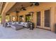 Spacious covered patio featuring travertine tile, an outdoor seating area, a ceiling fan, and views of the backyard at 1808 S Sailors Way, Gilbert, AZ 85295