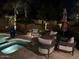 This poolside patio has a cozy seating area with a fire pit and umbrella at 1808 S Sailors Way, Gilbert, AZ 85295
