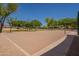 The community sand volleyball court has a net and is surrounded by trees at 1808 S Sailors Way, Gilbert, AZ 85295