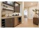 A stylish wet bar featuring wooden shelves and cabinets, a stainless-steel mini fridge, and wood flooring at 1808 S Sailors Way, Gilbert, AZ 85295