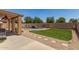 A backyard featuring lush green grass and a fenced pool with stone accents at 18903 N Shelby Dr, Maricopa, AZ 85138
