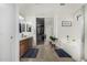 Bathroom with double sinks, soaking tub, tiled floors, and a large walk-in closet at 18903 N Shelby Dr, Maricopa, AZ 85138