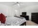 Bedroom with carpet, fan, TV, dark furniture and access to a bathroom at 18903 N Shelby Dr, Maricopa, AZ 85138