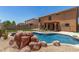 Backyard with an inground pool with rock features and desert landscaping at 18903 N Shelby Dr, Maricopa, AZ 85138