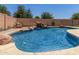 Inviting backyard pool featuring a rock waterfall, perfect for relaxation and outdoor enjoyment in a private setting at 18903 N Shelby Dr, Maricopa, AZ 85138