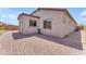Paver-covered backyard with desert landscaping and a neutral-colored stucco home at 18916 W Laurel Ln, Surprise, AZ 85388