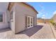 Paver-covered backyard with desert landscaping and a neutral stucco home with french doors at 18916 W Laurel Ln, Surprise, AZ 85388