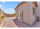 Paver-covered backyard with desert landscaping and a neutral stucco home with french doors at 18916 W Laurel Ln, Surprise, AZ 85388