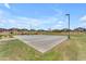 Outdoor community basketball court surrounded by grass and several neighborhood homes at 18916 W Laurel Ln, Surprise, AZ 85388